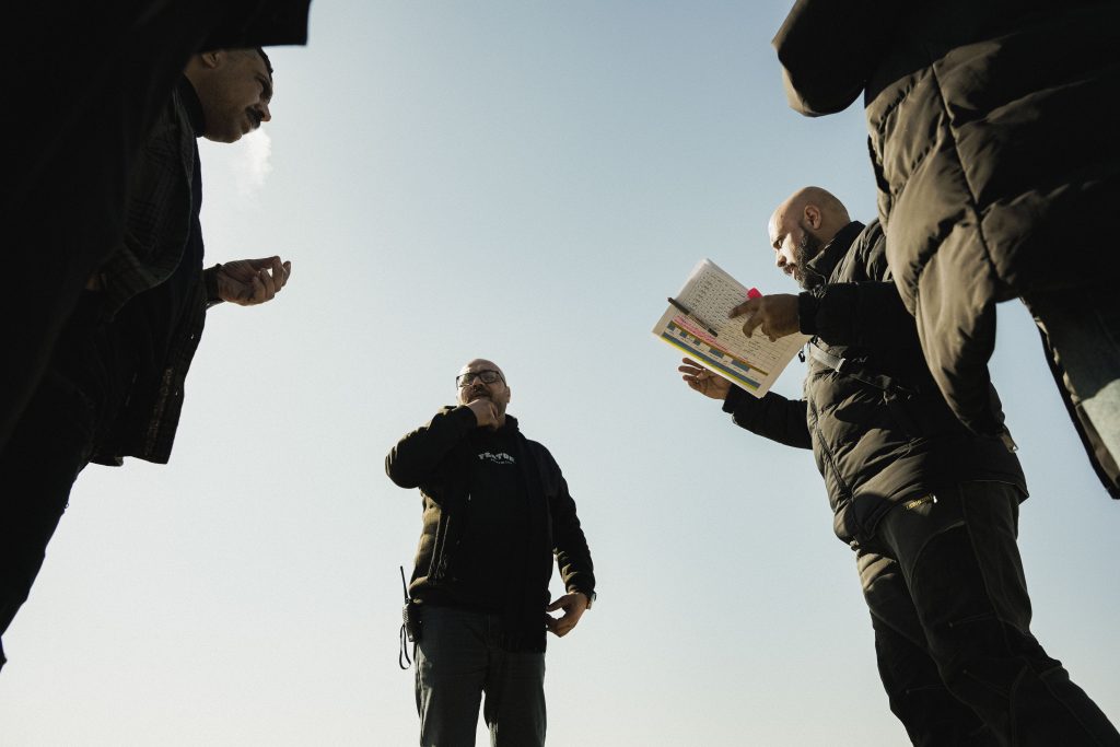 Group of men discussing something outdoors with notes and gestures