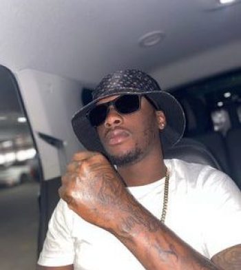 Young Bishop official picture in a car wearing a hat and glasses