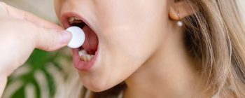 mother giving vitamin c pill to her child. dietary supplements for kids. Selective focus.