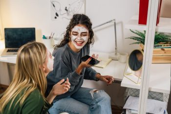 Two friends have fun with face masks on their face