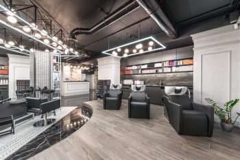 A modern hair salon interior with styling chairs, wash stations and pendant lights