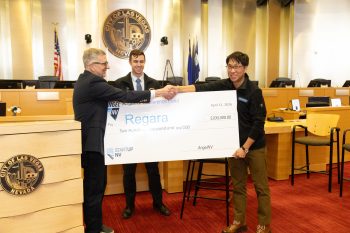 AngelNV presents a large check to startup Regara in a Las Vegas council chamber